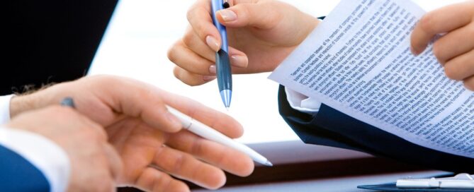 men at a table with documents